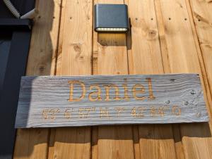 a sign that says damned on a wooden door at Tiny House Daniel in Papenburg