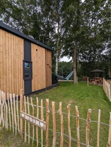a wooden fence with a playground in the background at Tiny House Daniel in Papenburg