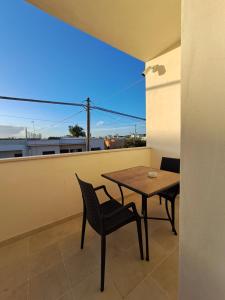 een tafel en stoelen op een balkon met uitzicht bij Casa Tizy in Botrugno
