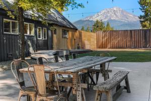 a wooden table and chairs with a mountain in the background at Shasta View Lodge in McCloud