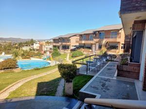 un balcón de una casa con piscina y sillas en ERNESTINA VILLAGE en Villa Carlos Paz