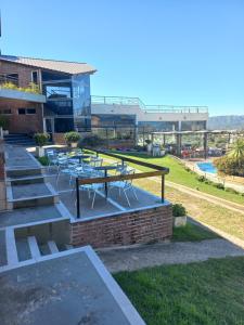 un patio avec des tables et des chaises en face d'un bâtiment dans l'établissement ERNESTINA VILLAGE, à Villa Carlos Paz