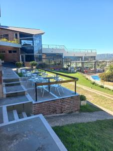a patio with tables and chairs in front of a building at ERNESTINA VILLAGE Resort Apart & suites in Villa Carlos Paz
