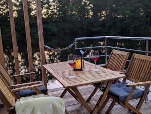 a wooden table with two glasses of wine on a deck at Hausboot Friedrich in Papenburg