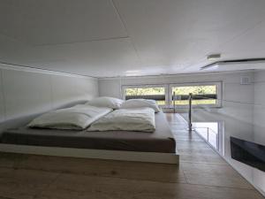 a bedroom with a large bed in a room with windows at Hausboot Friedrich in Papenburg