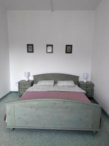 ブクにあるÉden Panzioのベッドルーム1室(木製ベッド1台、ナイトスタンド2台付)