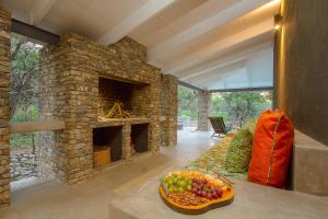 ein Wohnzimmer mit einem Steinkamin und einer Obstschale in der Unterkunft Kaja Noko in Marloth Park