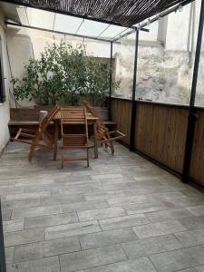 un patio con mesa, sillas y una planta en Beautiful Apartment With Terrace, en Aviñón