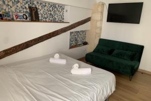 1 dormitorio con 1 cama y 1 sofá verde en Beautiful Apartment With Terrace, en Aviñón