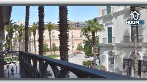 a balcony with palm trees in front of a building at Room 10 in Taranto