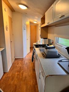 a kitchen with a stove and a counter top at Northumberland Caravan Holiday in Cresswell