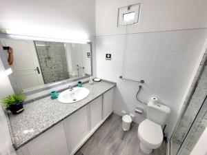 uma casa de banho com um lavatório, um WC e um espelho. em Apartamento Praia Fuzeta 2 em Fuzeta