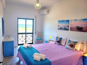 um quarto com uma cama grande e uma colcha rosa em Apartamento Praia Fuzeta 2 na Fuzeta