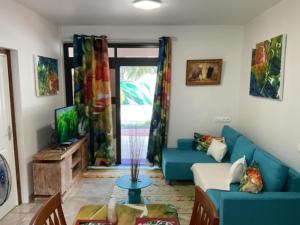 - un salon avec un canapé bleu et une table dans l'établissement RURUTU - Are Itimaana i Naairoa, à Rurutu
