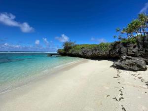 una playa con huellas en la arena y el océano en RURUTU - Are Itimaana i Naairoa en Rurutu