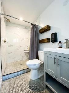 a bathroom with a toilet and a shower and a sink at Roomi in Los Angeles