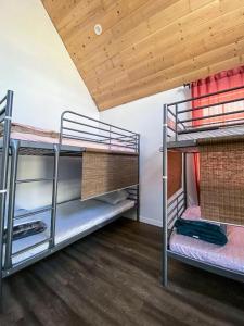two bunk beds in a room with a wooden ceiling at Roomi in Los Angeles