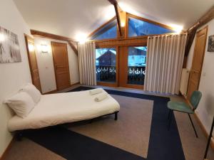 Zimmer mit einem Bett und einem großen Fenster in der Unterkunft Duplex with garden Mountain view in Les Houches