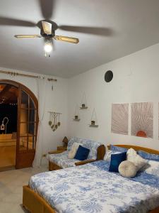 a bedroom with two beds and a ceiling fan at Villa Katy in Panarea