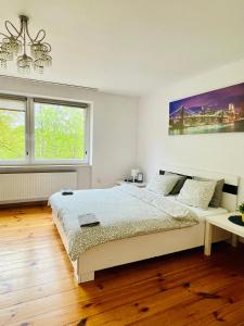 a white bedroom with a bed and two windows at Pokoje Slawin in Lublin