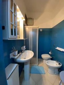 a blue bathroom with two sinks and a toilet at Villa Katy in Panarea
