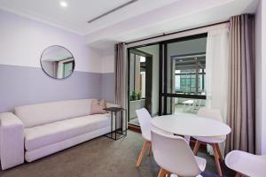 - un salon avec un canapé et une table dans l'établissement Dream Central Apartment with Pool, Spa & Gym, à Auckland