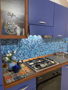 a kitchen with purple cabinets and a stove top oven at Villa Katy in Panarea