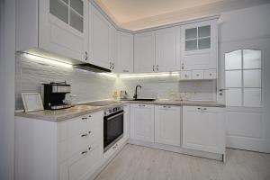 Una cocina blanca con gabinetes blancos y un microondas. en Tulip Dreamland, en Sofía 27 fotos más
