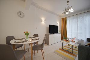 Una sala de estar con una mesa y sillas y un televisor. en Tulip Dreamland, en Sofía