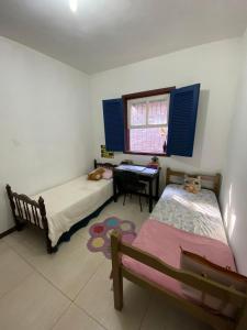 a bedroom with two beds and a table and a window at República Xamego in Ouro Preto