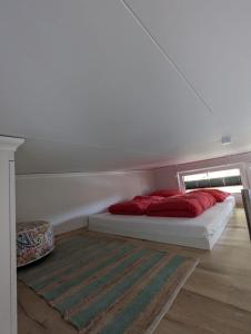 uma cama com duas almofadas vermelhas num quarto em Tiny House Nelson em Papenburg
