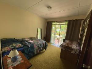 1 Schlafzimmer mit 2 Betten, einem Tisch und einem Fenster in der Unterkunft ROOM LE BASSIN in Tiarei