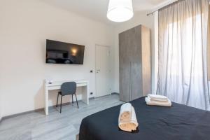 Un dormitorio con cama, escritorio y televisión. en Amazing apartment near to Colosseo and subway, en Roma
