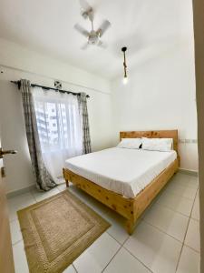 Schlafzimmer mit einem Bett und einem Deckenventilator in der Unterkunft Serenity Haven, 1 BR, Pool, Wi-Fi, IPTV, Netflix, Air Conditioner in Mombasa