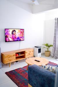 ein Wohnzimmer mit einem TV an der Wand in der Unterkunft Serenity Haven, 1 BR, Pool, Wi-Fi, IPTV, Netflix, Air Conditioner in Mombasa