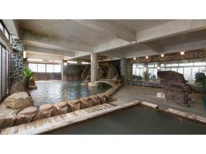 a swimming pool in a large building with a pool at Myoken Onsen Nemu - Vacation STAY 20783v in Kirishima
