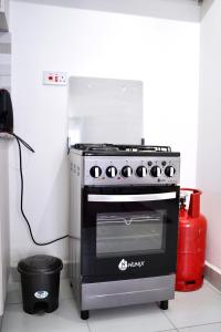 a black stove in a kitchen with a fire extinguisher at Serenity Haven, 1 BR, Pool, Wi-Fi, IPTV, Netflix, Air Conditioner in Mombasa