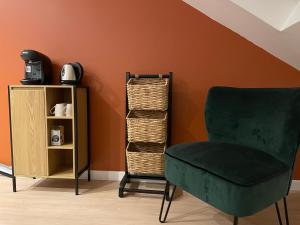 einen grünen Stuhl neben einem Bücherregal in der Unterkunft Bel appartement 2 chambres 