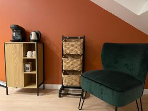 a green chair sitting next to a book shelf at Bel appartement 2 chambres in Ham
