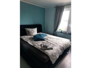 een slaapkamer met een bed met blauwe muren en een raam bij Holiday apartment garden magic 
