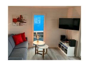 un soggiorno con un divano, un tavolo e una TV di Isa-Bella Comfortable holiday residence a Burgtiefe auf Fehmarn 