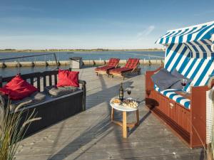 a deck with couches and a table on the water at Houseboat Isa-Bella in Burgtiefe auf Fehmarn 