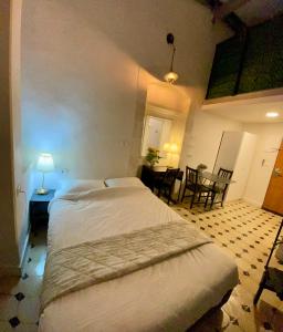 a bedroom with a large bed and a table and chairs at מלון בירת החומות• The Walled Capital Hotel in Jerusalem