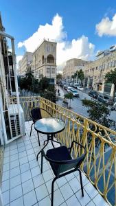 Un balcón con una mesa y sillas y una calle. en מלון בירת החומות• The Walled Capital Hotel, en Jerusalén