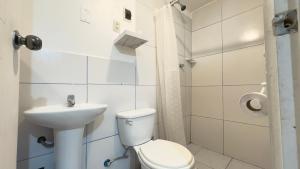 Un baño blanco con inodoro y lavabo. en Casona Libertrek Inn, en Cusco 199 fotos más