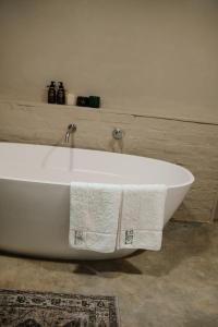 a white bath tub with two white towels on it at Rest Guesthouse in Dullstroom +45 photos