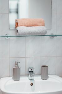 een badkamer met een wastafel met een spiegel en handdoeken bij Raimond Apartment Top 27 in Wenen
