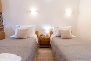 two beds sitting next to each other in a room at Almyra Apartments & Studios in Agios Gordios