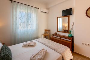 una camera da letto con un letto con specchio e una cassettiera di Queen bee seafront a Kampos Paros