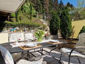 einen Tisch mit Tellern und Blumen auf einer Terrasse in der Unterkunft Ferienwohnung Leitnhax in Berchtesgaden